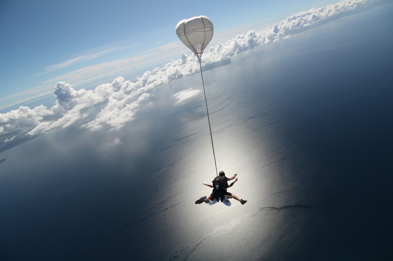Tandem skydiving experience - Smiling jumper enjoying freefall with professional instructor
